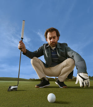 Man wearing Dockers® - Golf Ready collection – sitting on the course after a round of golf